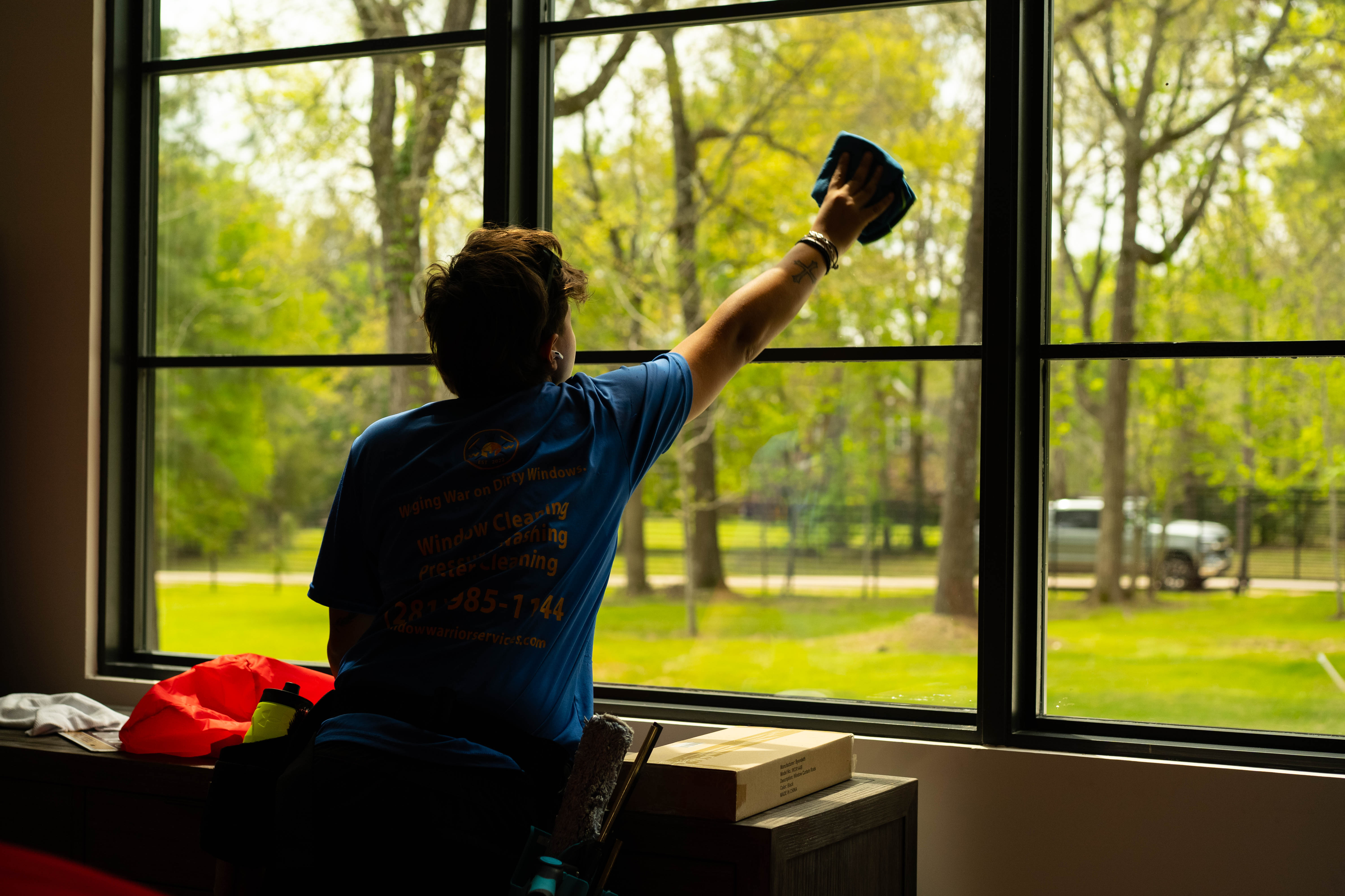 Technician wiping down a large picture window