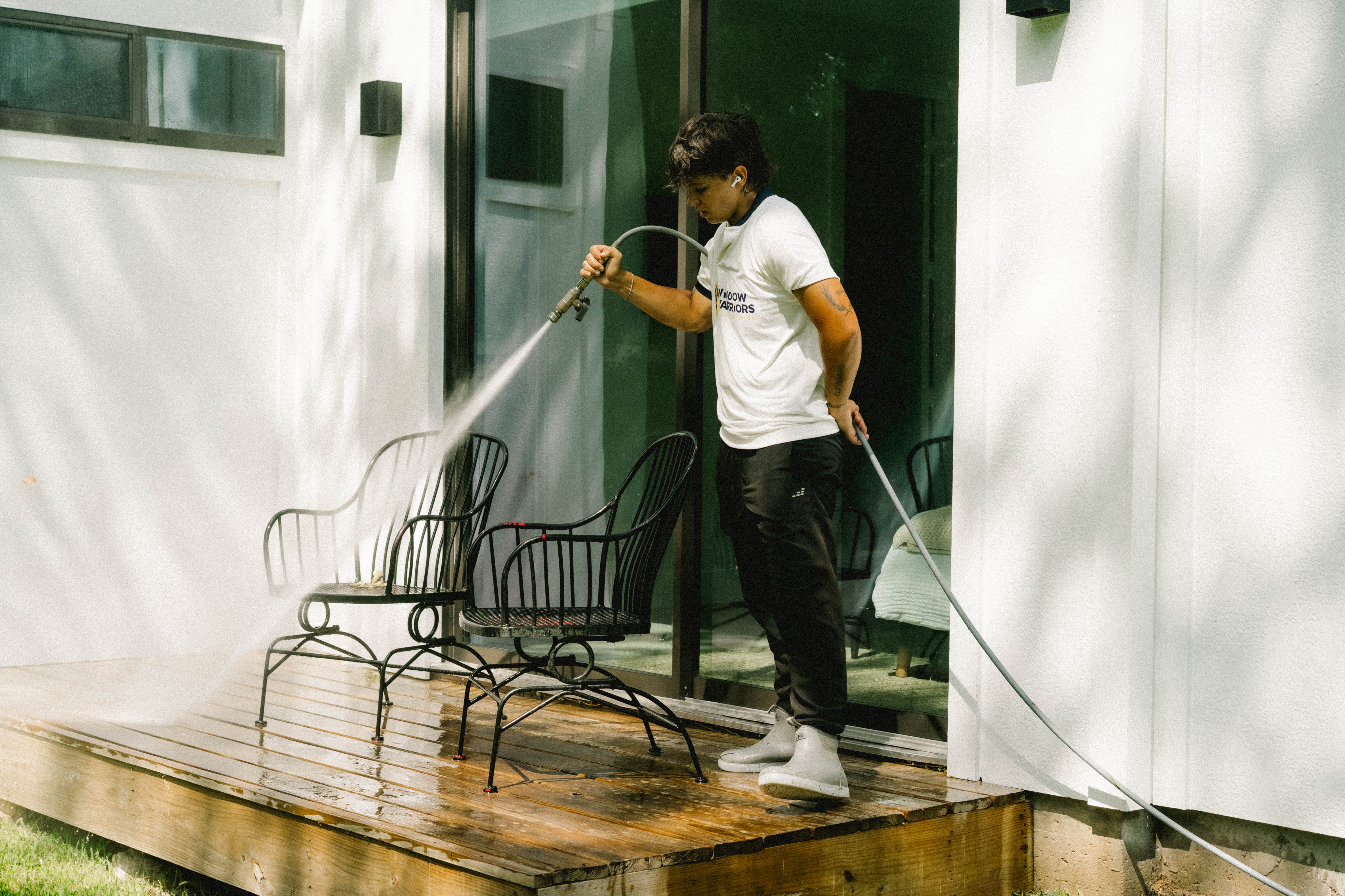 Rinsing patio furniture during a pressure washing visit