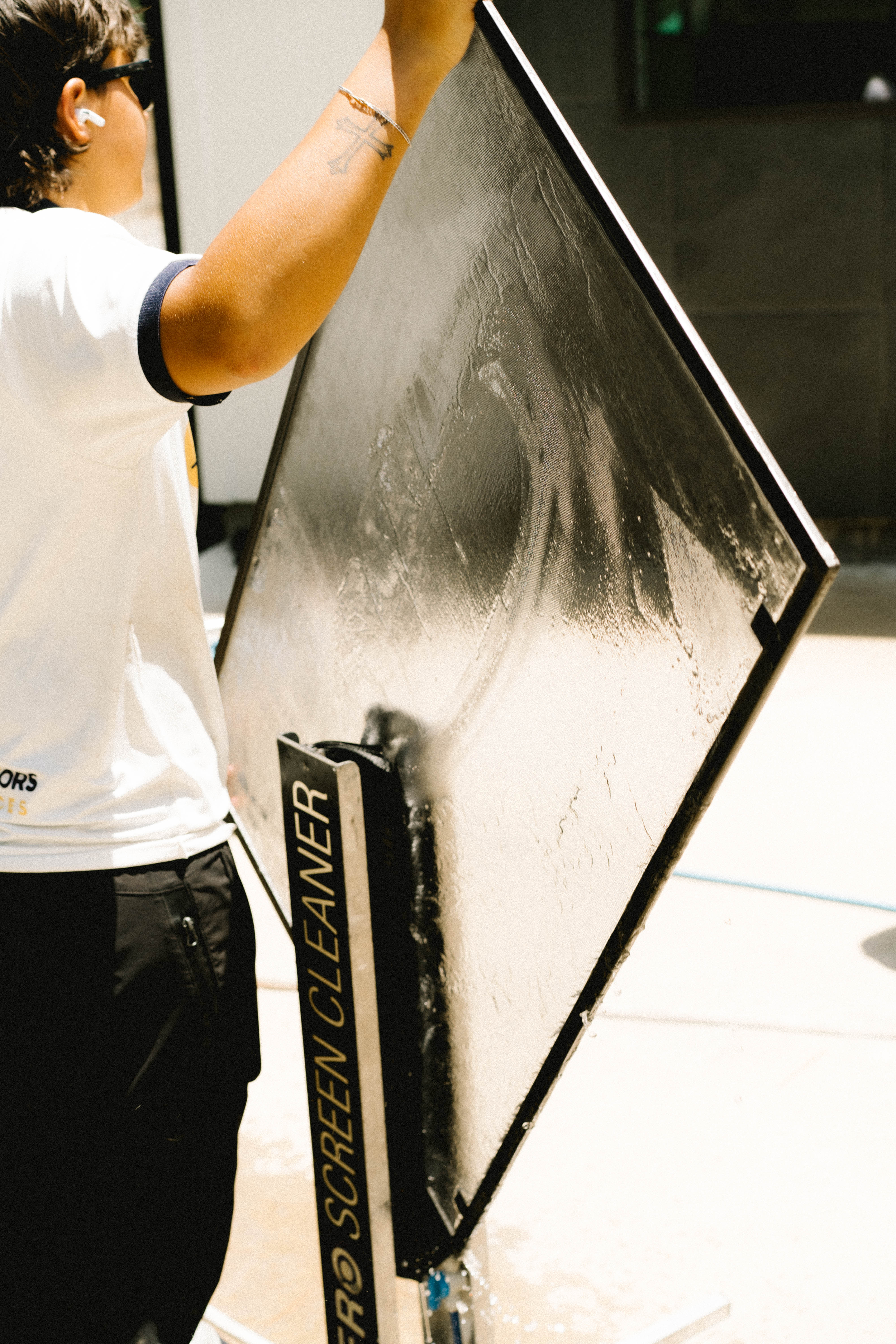 Window Warriors technician cleaning a window screen with a dedicated screen cleaning tool