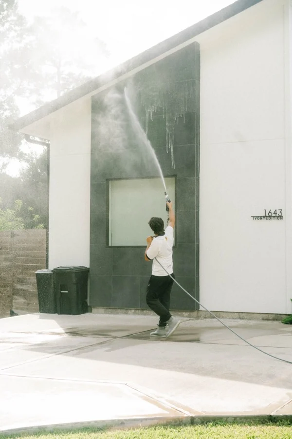 Power Washing exterior siding on a modern white Houston home