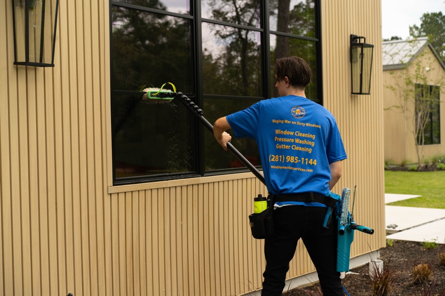 Technician washing exterior windows