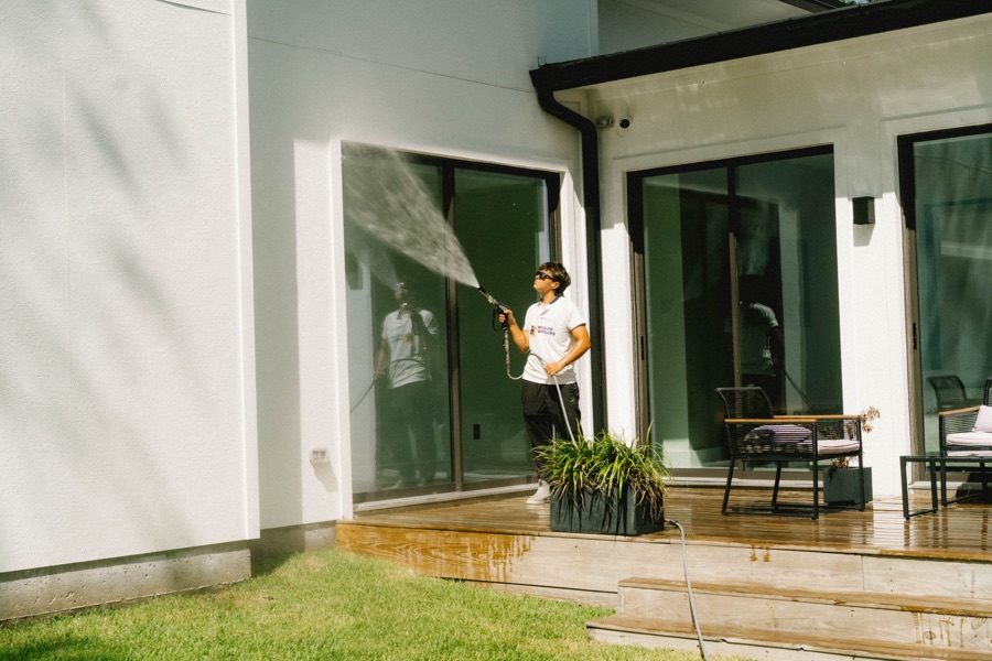 Window spray cleaning near landscaping